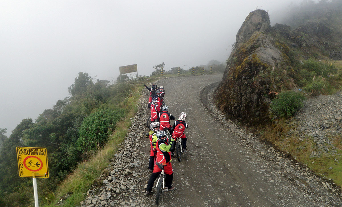 Mountainbikers staan stil bij de death road in bolivia