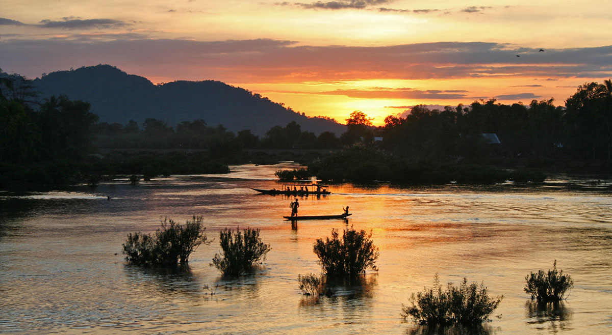 Zonsondergang met boten op mekong bij si pan don in Laos.