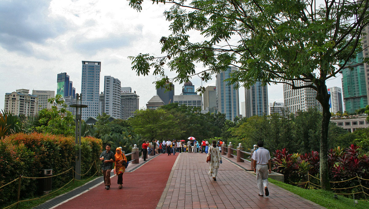 Wandelaars bij moderne gebouwen in Kuala Lumpur.