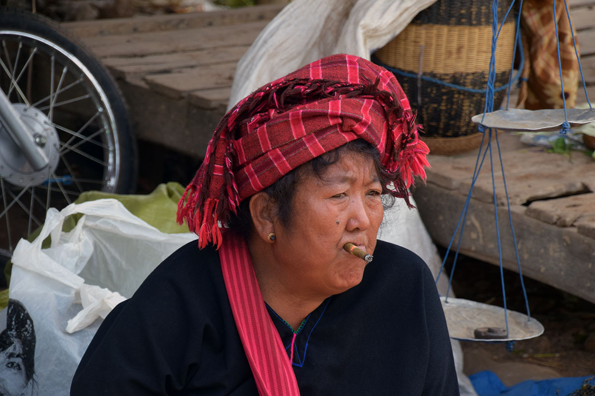 Traditionele vrouw met sigaar op markt bij het Inle Lake.