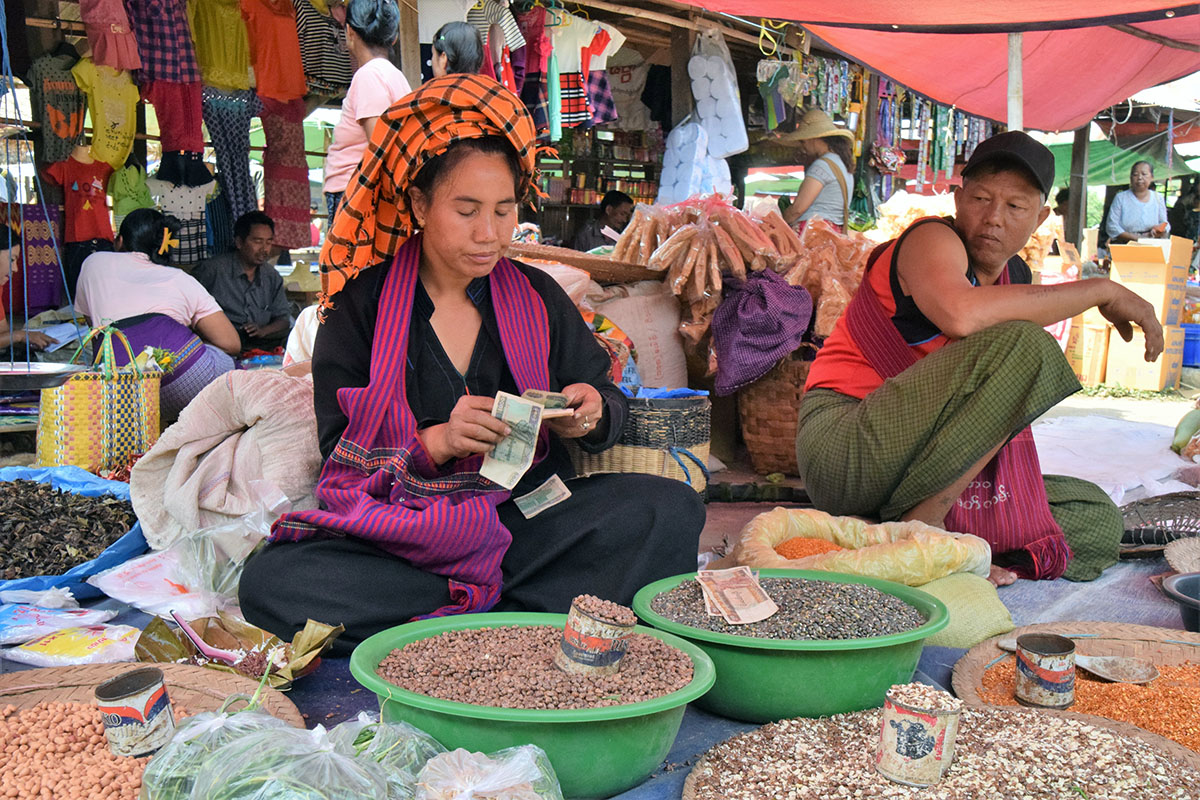 handelsvrouw op markt bij het Inle Lake telt haar geld.