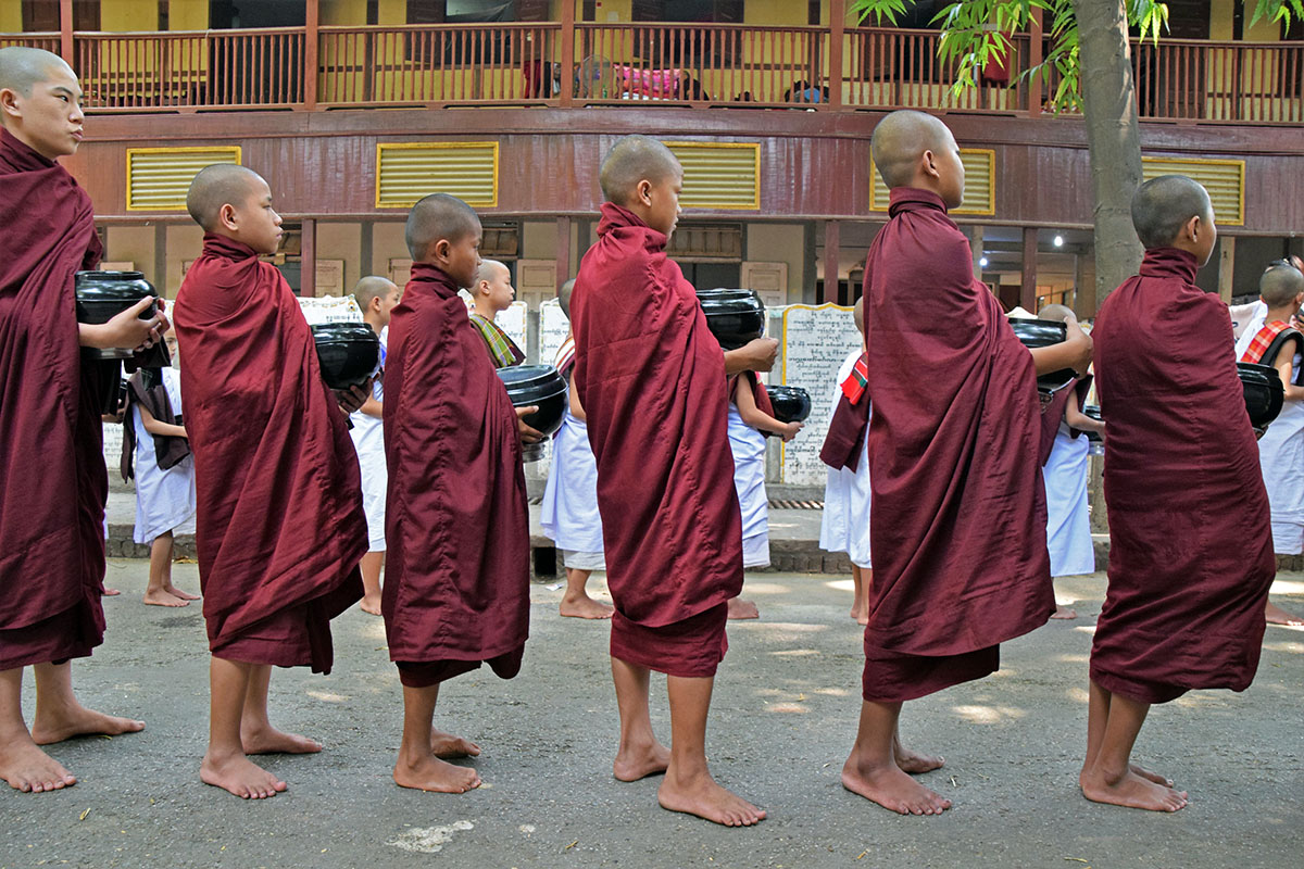 Jonge monniken met hun blote voeten bij mahagandayon monastery