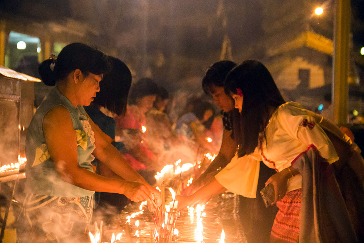 Kaarsen aansteken bij de Shwedagon Paya.