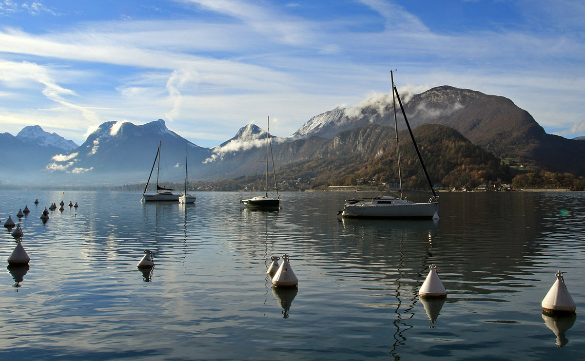 Boten op het meer van Annecy, omgeven door bergen.