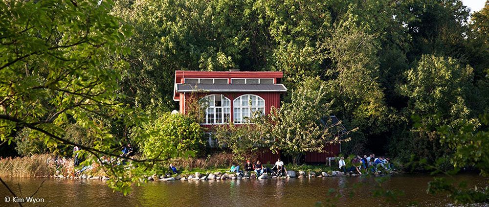 People sitting by water at a house in Christiania