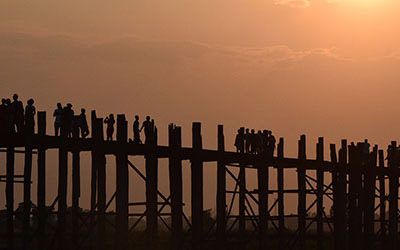 Over de U-Bein Bridge lopen bij zonsondergang