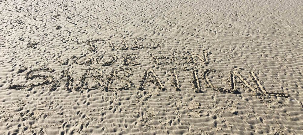 Bericht in het strandzand geschreven over een sabbatical nemen