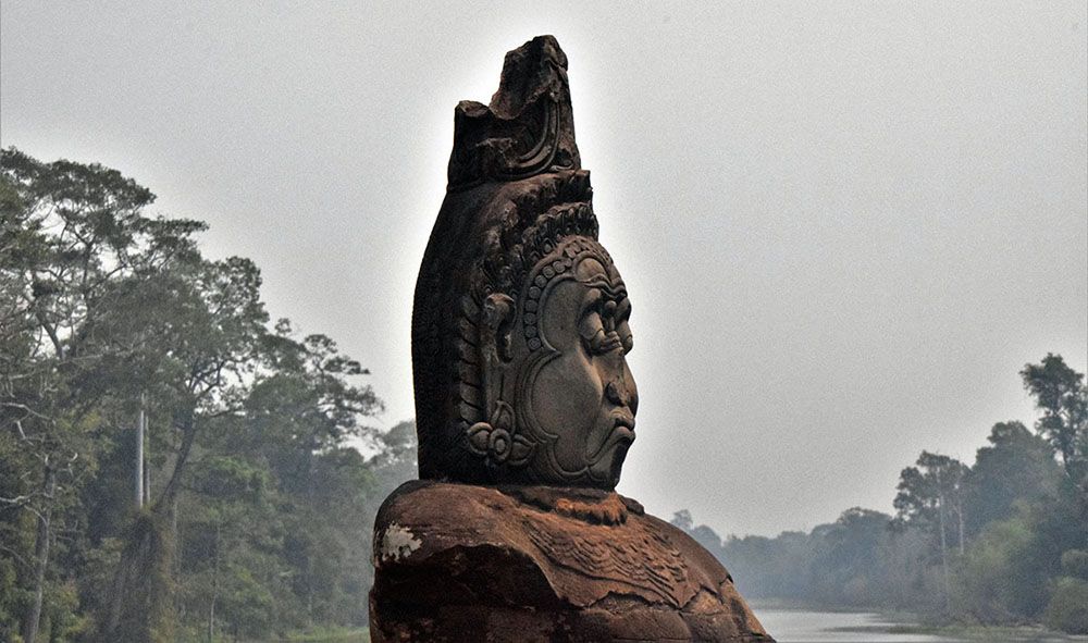 Beeld van vrouw op de balustrade bij rivier bij Angkor Wat.