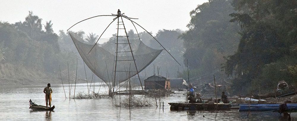 vissers met enorm visnet op rivier bij Siem Reap.