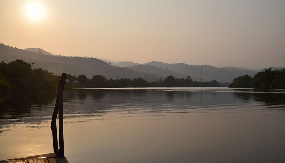 Zonsondergang bij rivier in de regio Kampot