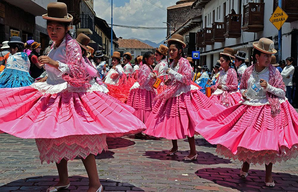 Kleurrijke straatparade met dansende vrouwen in Cuzco