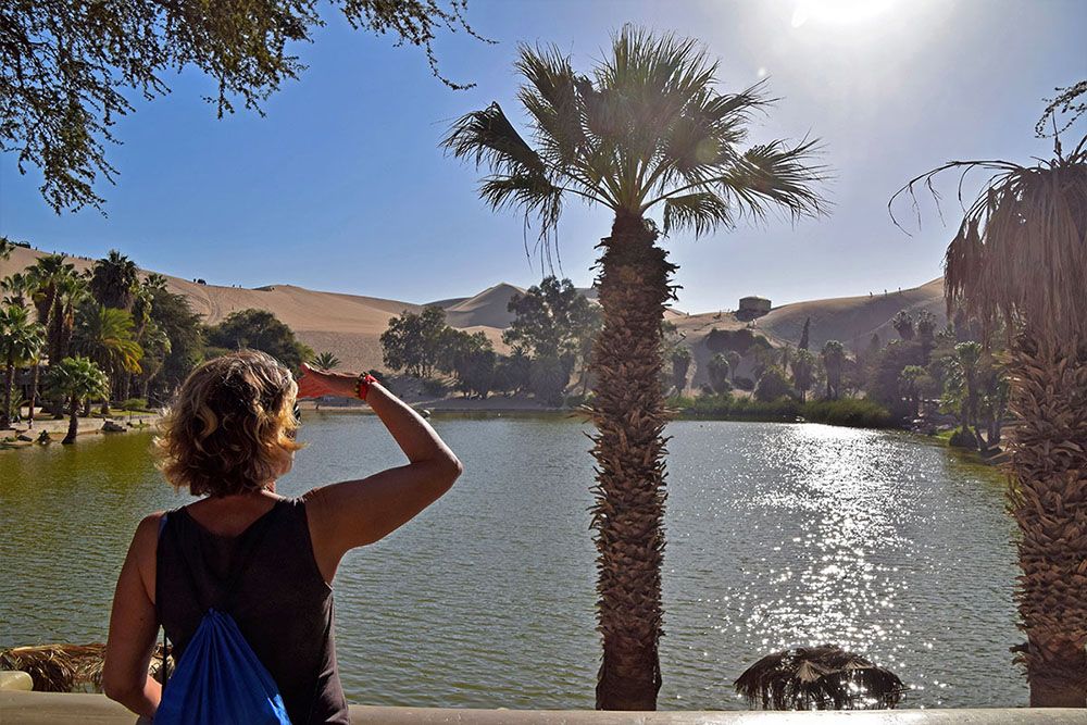 Toerist kijkt uit over het meertje in Huacachina